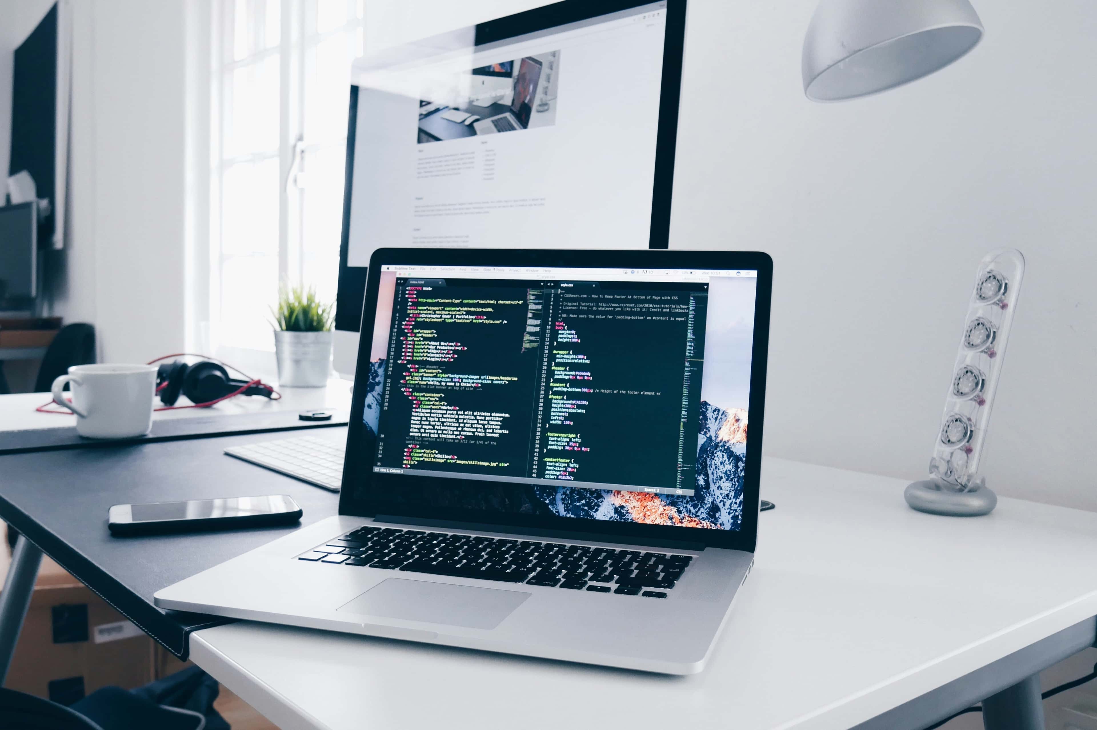 Modern web developer working on responsive website design with multiple device screens